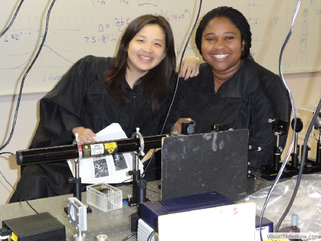 Lily Zhang '12 and Ijeoma Ekeh '12 with the open cavity helium neon laser.