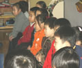 children seated in a line, listening